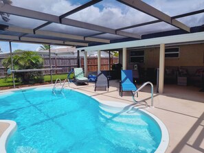 A covered swimming pool with lounge chairs and a patio area. - Private HEATED Pool home in Port Richey / Essentials Provided during your stay  (Port Richey)