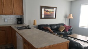 Una cocina compacta con armarios de madera, una isla integrada y una cafetera.