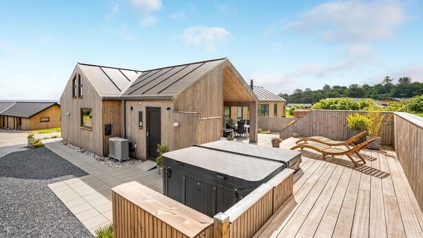 A modern wooden building with a hot tub and outdoor seating area. - 4 bedroom stunning home in Sjølund (Sjølund)
