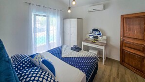 A bedroom with a bed, a desk, a wardrobe, and an air conditioning unit. - Stunning home in Galizana (Galizana)