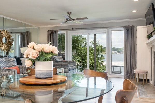 Relax in this serene space with a glass dining table and comfortable seating, surrounded by a stunning view of the water.
