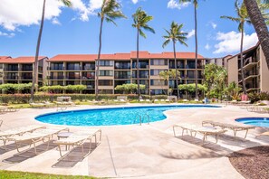 A hotel with a large pool, palm trees, and a red-roofed building. - Ocean views with Hawaiian-inspired decor (Lahaina)