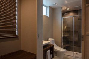 A modern bathroom with a shower, toilet, and sink.