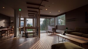 Ein modernes Interieur mit einer Holzeinrichtung, einer Couch und Blick ins Freie.