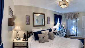 A bedroom with a bed, bedside table, lamp, dresser, mirror, and a TV mounted on the wall. - Country Escape Home in the Woods- Chesapeake, VA (Chesapeake)