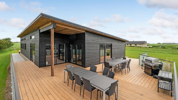 A modern house with a deck, outdoor seating, and a grill. - Lovely home in Spøttrup with WiFi (Spøttrup)