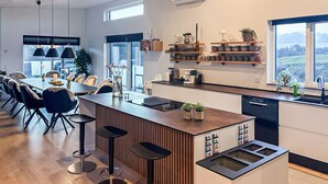 A modern kitchen with a central island, bar stools, and a dining area with chairs. - Lovely home in Spøttrup with WiFi (Spøttrup)