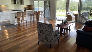 A spacious living area with a kitchen, dining area, and a patio with outdoor furniture.