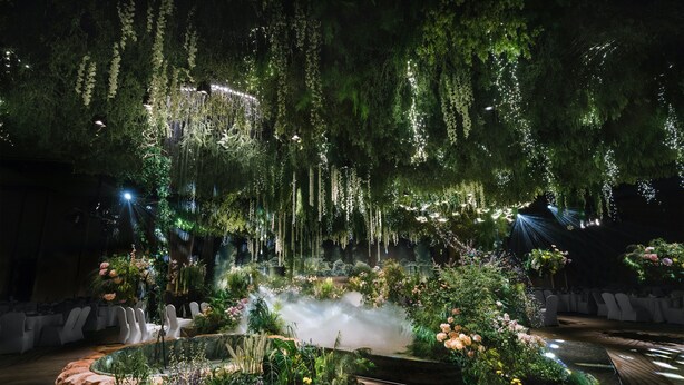 A lush indoor garden with hanging plants, a mist feature, and white chairs arranged for seating. - Holiday Inn Zhengzhou High Tech Zone by IHG (Zhengzhou)