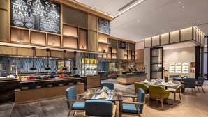 A modern restaurant with a bar area, seating for 20, and a large menu board displaying various dishes. - Holiday Inn Zhengzhou High Tech Zone by IHG (Zhengzhou)