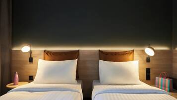Una habitación de hotel con dos camas, una mesita de noche, una lámpara y un bolso sobre la mesita.