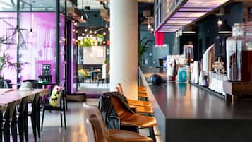 A modern cafe interior with seating, a counter, and a bar area.