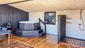 Un intérieur moderne avec un jacuzzi, un plancher en bois et un espace douche.