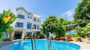 Una piscina con un edificio blanco al fondo.