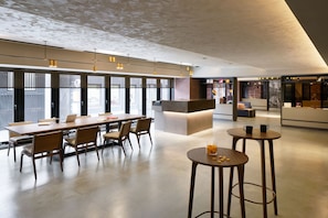 Meet and collaborate in this open-plan space with a long table and comfortable chairs, or relax at the small round table with stools.