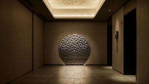 A hallway with a skylight, a textured wall, and a door. - the b ginza (Tokyo)