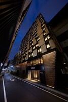 A modern building with a unique facade and illuminated windows at night.