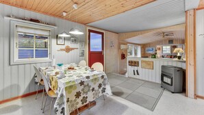 Ein gemütliches Blockhaus-Interieur mit Essbereich, Küche und einer roten Tür.