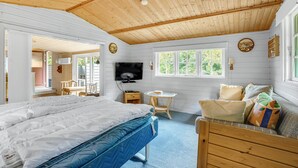 Ein gemütliches Zimmer mit Bett, Fernseher, kleinem Tisch und Fenster.