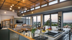 A modern kitchen with a large island, large windows, and a view of the city. - Executive 9 bedroom villa with a heated pool (Daratsos)