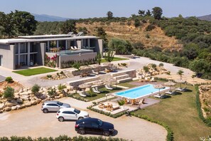 A modern villa with a swimming pool, outdoor seating, and a parking area. - Executive 9 bedroom villa with a heated pool (Daratsos)
