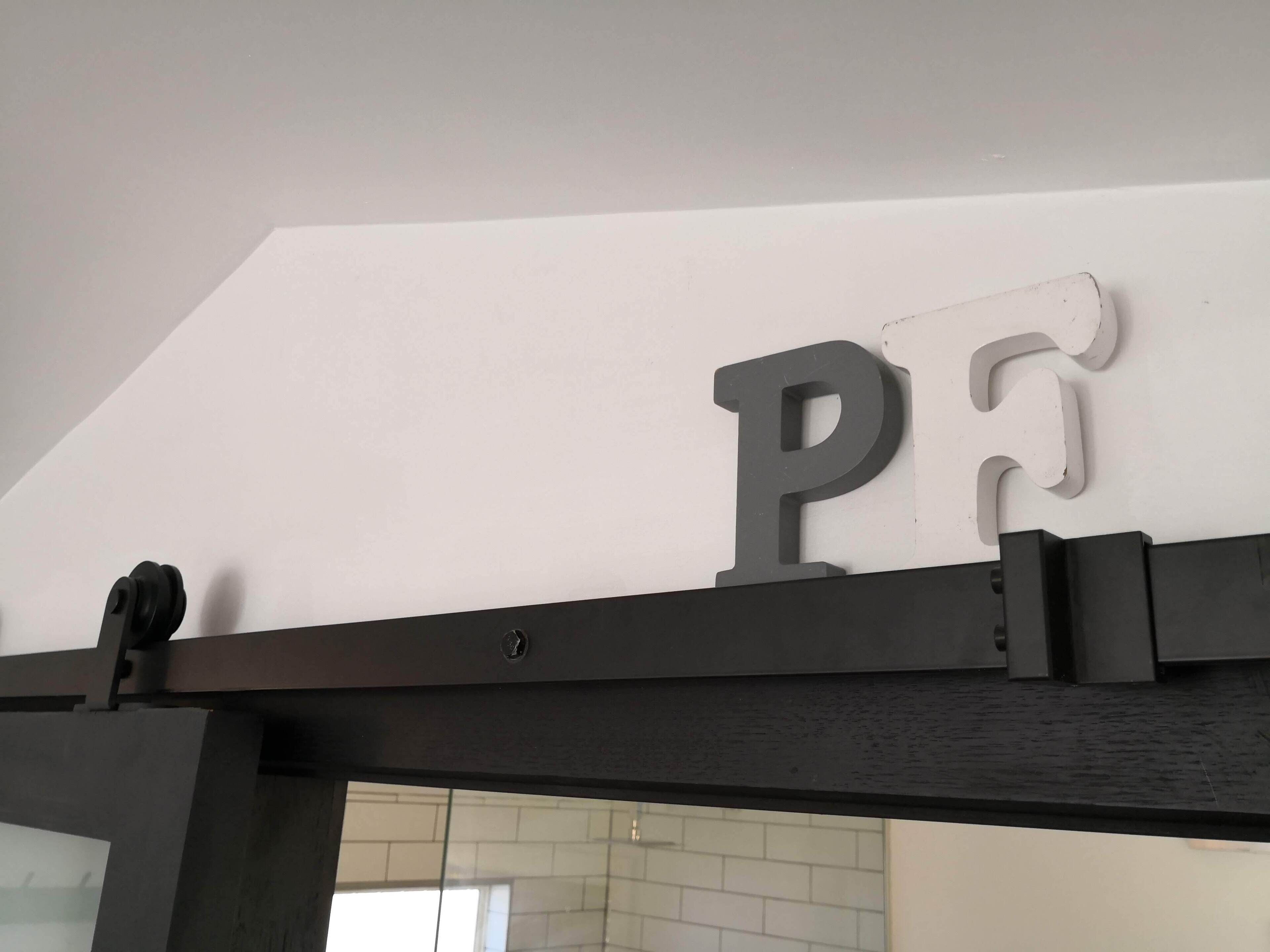 A black metal frame with a white wall in the background.