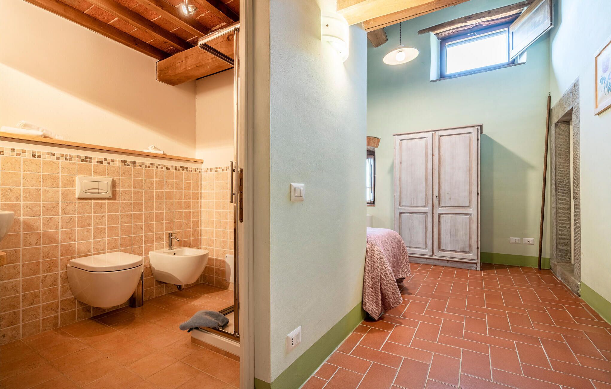 A bathroom with a toilet, bidet, and shower.