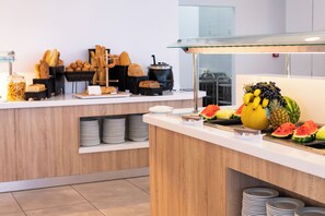 A buffet area with various food items and utensils.