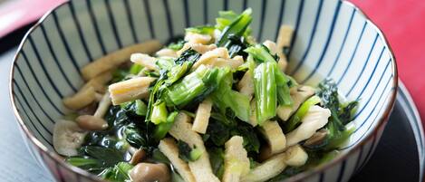 A bowl of stir-fried vegetables with tofu and mushrooms.