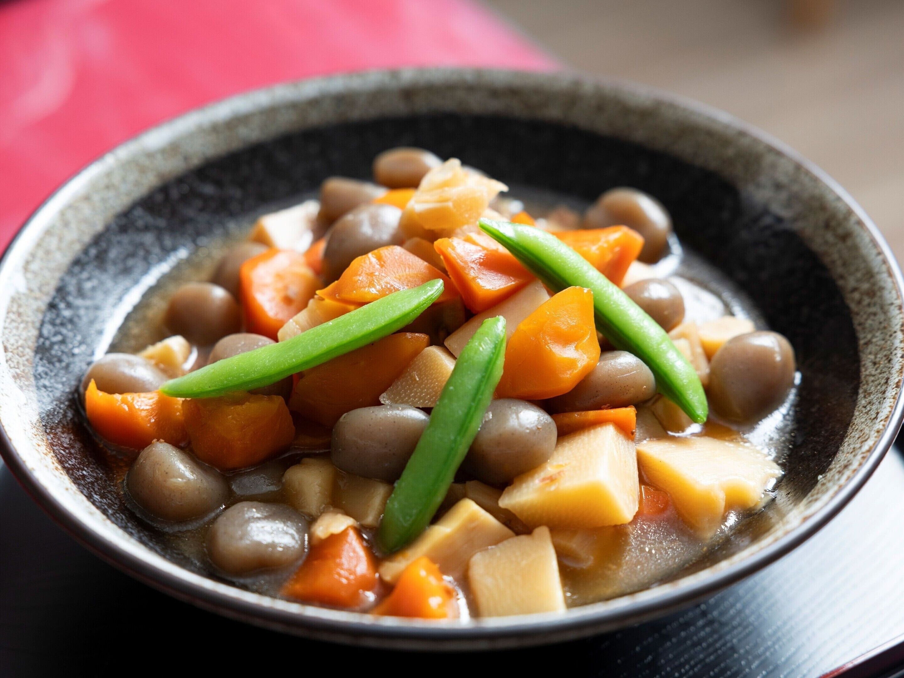A bowl of stew with vegetables and beans.