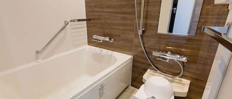 Un baño moderno con bañera, ducha, inodoro y lavabo.
