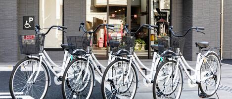 A row of bicycles parked in front of a building with a visible handicapped parking sign.