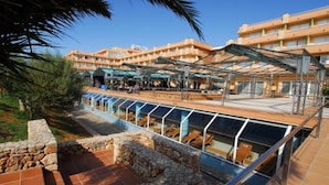 A hotel with a pool area, outdoor seating, and a covered walkway. - Hotel Mariant Park (Sant Llorenc des Cardassar)