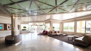 A spacious lobby with a high ceiling, large windows, and a central seating area with sofas and a coffee table. - Hotel Mariant Park (Sant Llorenc des Cardassar)