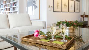 A glass-top table with a wicker tray, two champagne flutes, a bowl of cookies, and a pink flower. - 2 bedroom nice apartment in Cádiz (Cádiz)