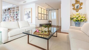 A modern living room with a glass coffee table, white sofas, a bookshelf, framed artwork, and a decorative mirror. - 2 bedroom nice apartment in Cádiz (Cádiz)