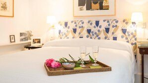A neatly made bed with a tray of champagne glasses and flowers, a patterned headboard, and framed artwork on the walls. - 2 bedroom nice apartment in Cádiz (Cádiz)