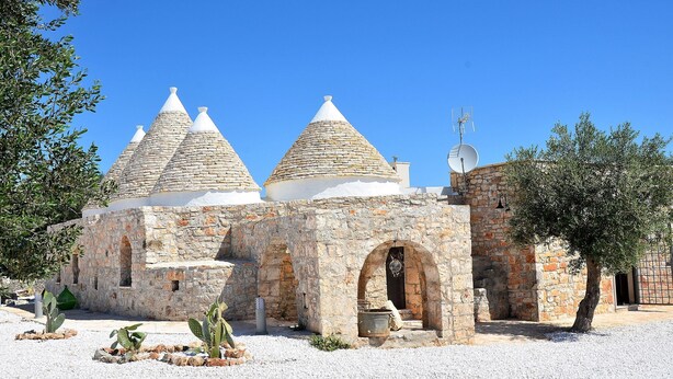 A stone building with three conical roofs and a satellite dish. - Modern trulli, 3 bedrooms, air conditioning, private swimming pool, pétanque court. (Castellana Grotte)