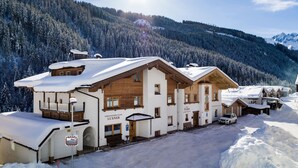 A snow-covered building with a sign reading "Ferienwohnungen Luxner" in a mountainous area. - Apartment mit 3 Schlafzimmern und Balkon (Gerlos)