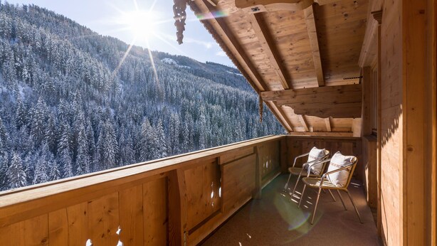 A wooden cabin with a balcony overlooking a snow-covered forest. - Apartment mit 3 Schlafzimmern und Balkon (Gerlos)