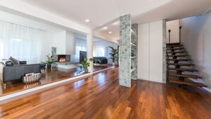 A spacious living area with hardwood flooring, a modern staircase, and a fireplace. - Villa Ninetta 10+1, Emma Villas (Giulianova)