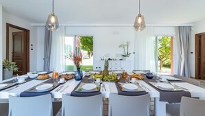 A dining area with a long table set for multiple guests, featuring a variety of fruits and beverages. - Villa Ninetta 10+1, Emma Villas (Giulianova)