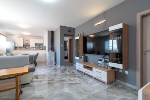 A modern living room with a flat-screen TV, a wooden coffee table, and a marble floor. - ANTONIO, 2-bedroom apartment with splendid view, OKRUG GORNJI (Okrug Gornji)