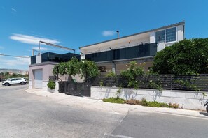 A modern two-story house with a garage, a balcony, and a driveway.