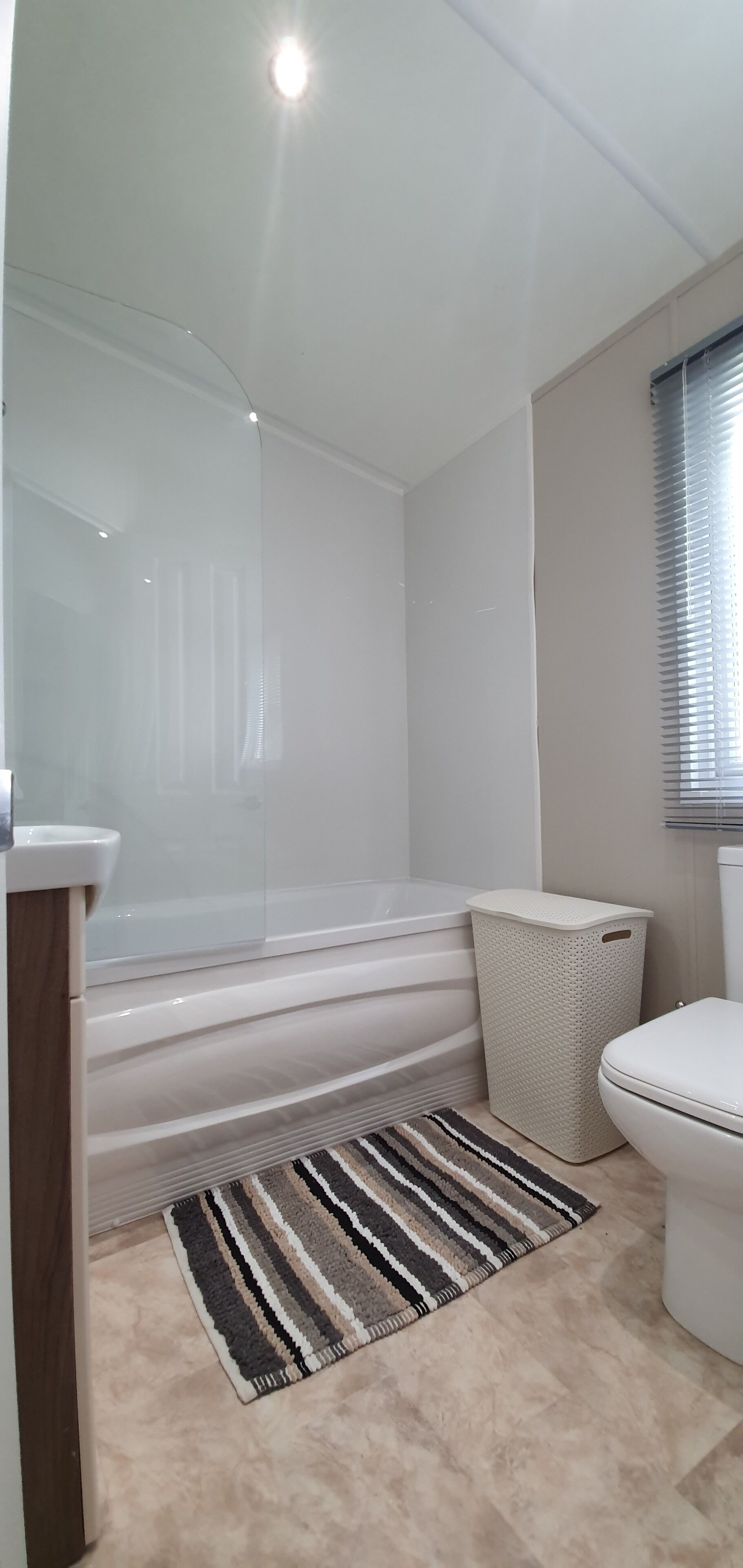 A modern bathroom with a bathtub, toilet, and shower area.