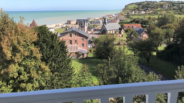 A coastal town with a prominent church, residential buildings, and a view of the sea. - Roses,turn of the century house 100 meters from the sea (Hautot-sur-Mer)