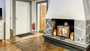 Un salón moderno con chimenea de piedra, suelo de madera y una puerta blanca.
