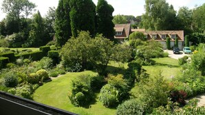 Une maison avec un jardin bien entretenu, une allée et une voiture garée dans l’allée.