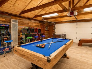 A pool table with surrounding arcade games and a foosball table in a wooden room. - Evergreen Paradise - Hot Tub, Game Room, Pool Table, Foosball (Big Bear Lake)
