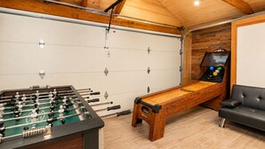Una stanza con un tavolo da calcio, una panca e un tavolo da calcio con segnapunti.